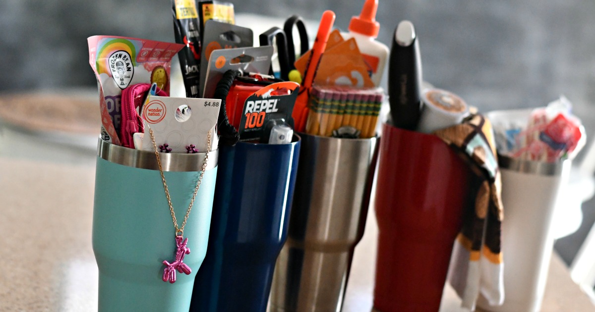 DIY Tumbler Gift basket ideas – five tumblers lined up with items inside