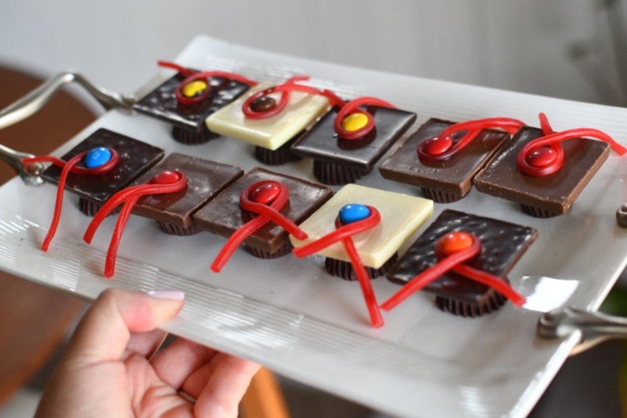 hand holding tray of white and dark chocolate grad caps