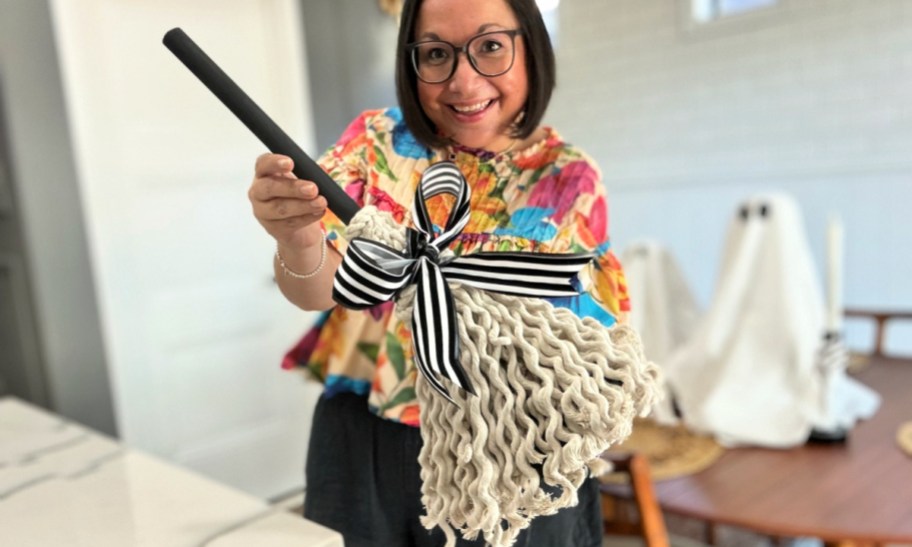 woman holding a witch broom plunger