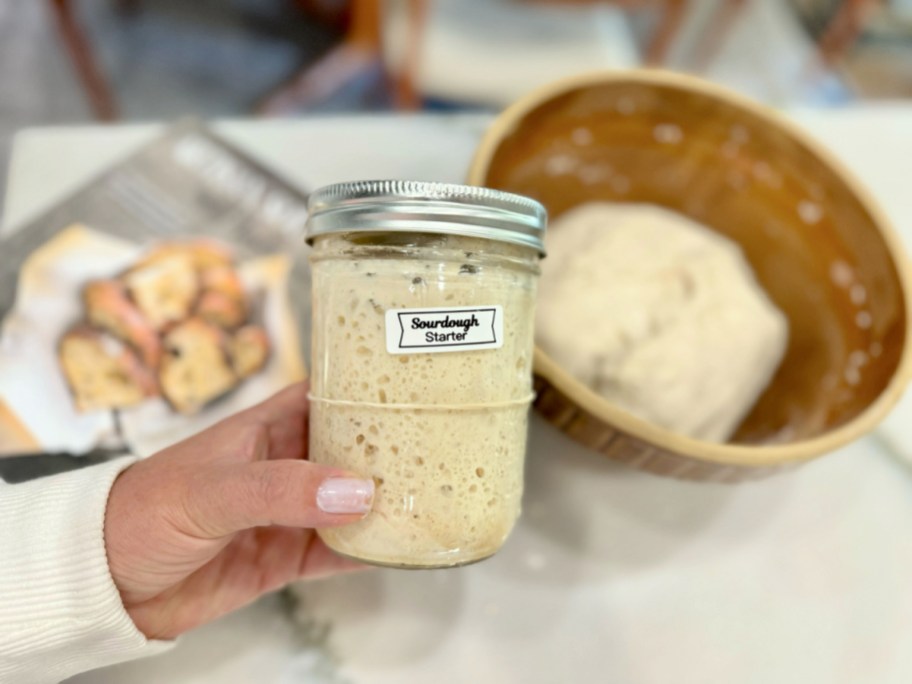 woman holding a sourdough starter