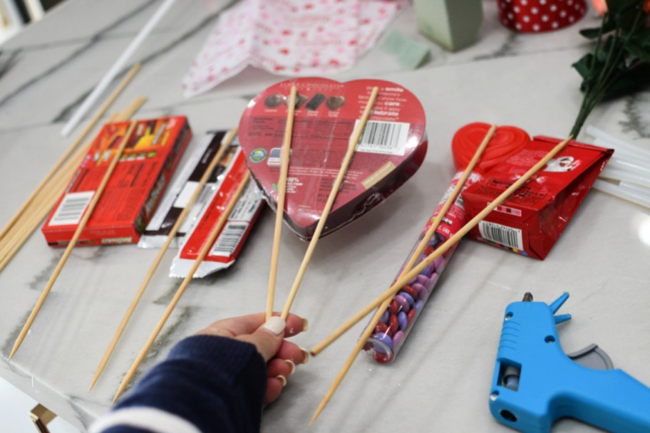 using hot glue to secure wood skewers to candy