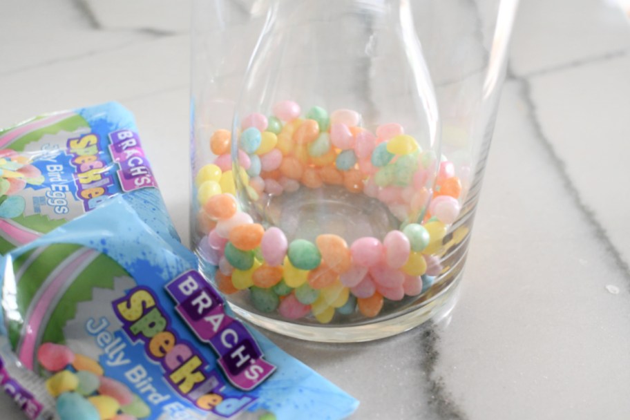 adding jelly beans to glass vase