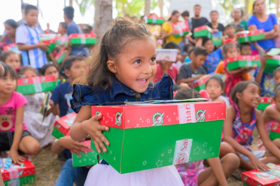 a participant of operation christmas child holding a shoebox 