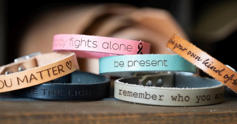 a stack of engraved leather bracelets