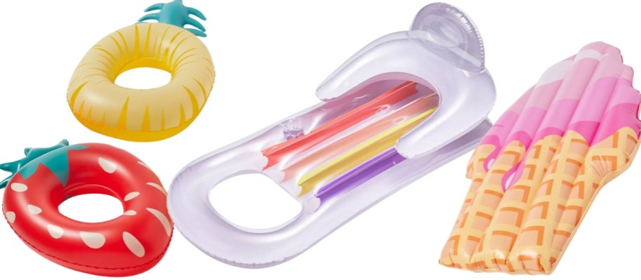 strawberry and pineapple pool floats, a large white and multicolor pool float and an ice cream cone pool float