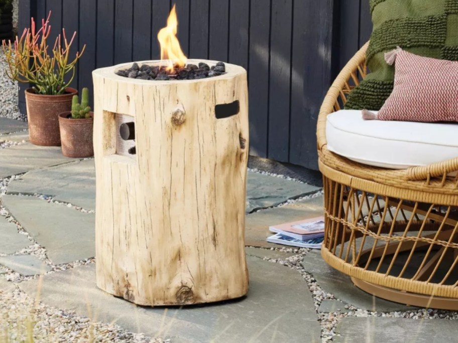 a round rustic wood look fire pit on a patio