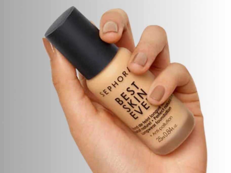 hand holding a bottle of makeup foundation