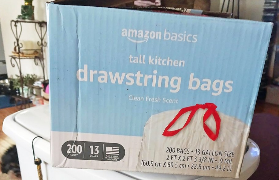 large blue box of Amazon Basics 13-Gallon Drawstring Trash Bags