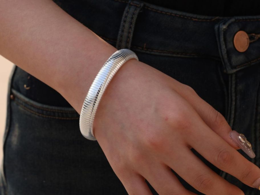 A woman wearing a silver bangle bracelet 