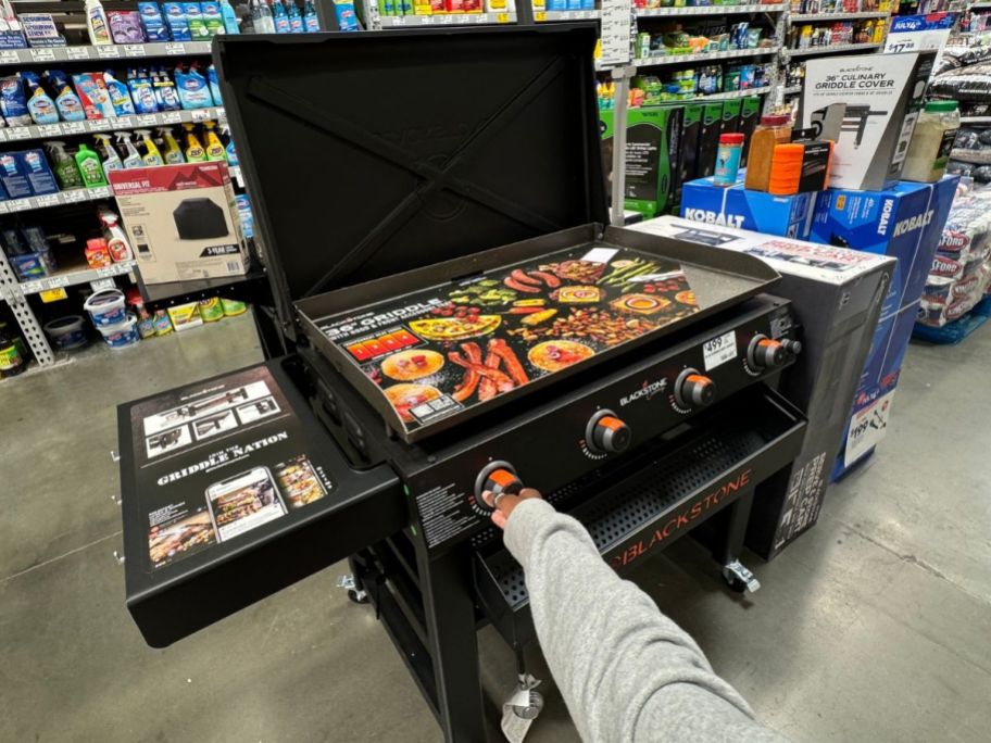 Hand touching the knob on a Blackstone 36" Omnivore Griddle