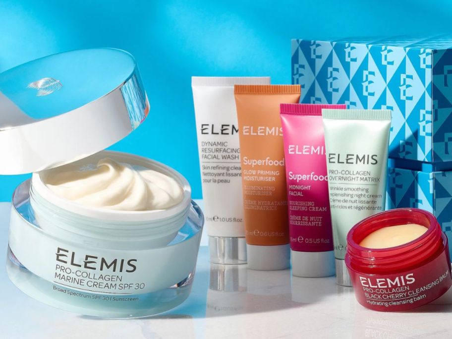 Image of an open Elemis Pro-Collagen Marine Cream next to 5 other Elemis skincare products