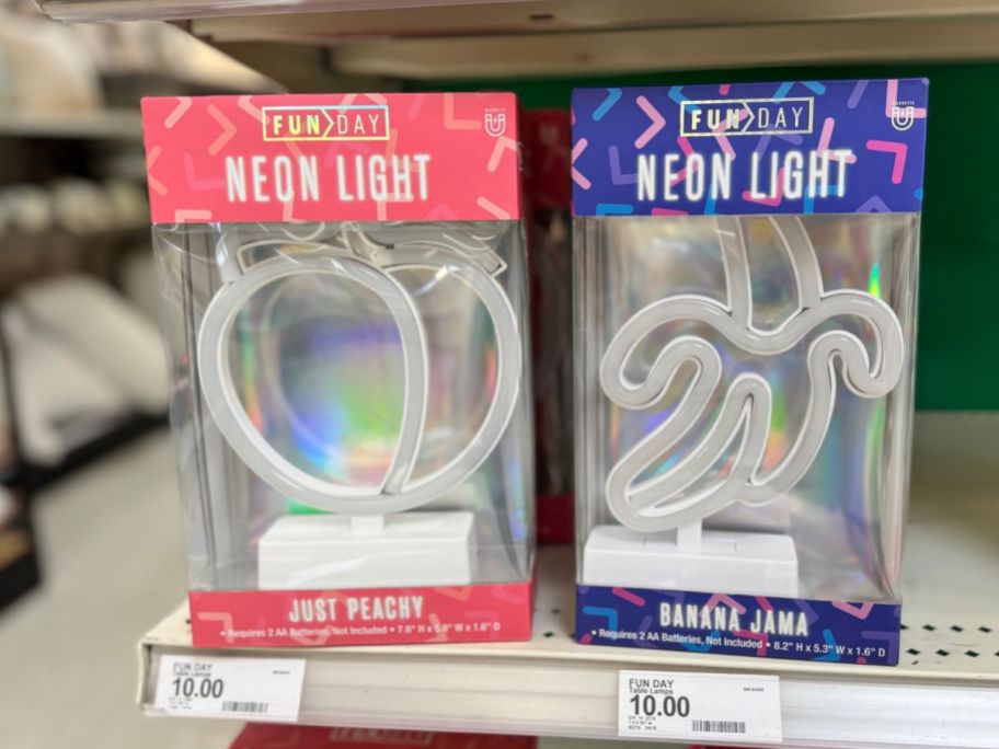 A peach-shaped and a banana-shaped neon light in a box at a store