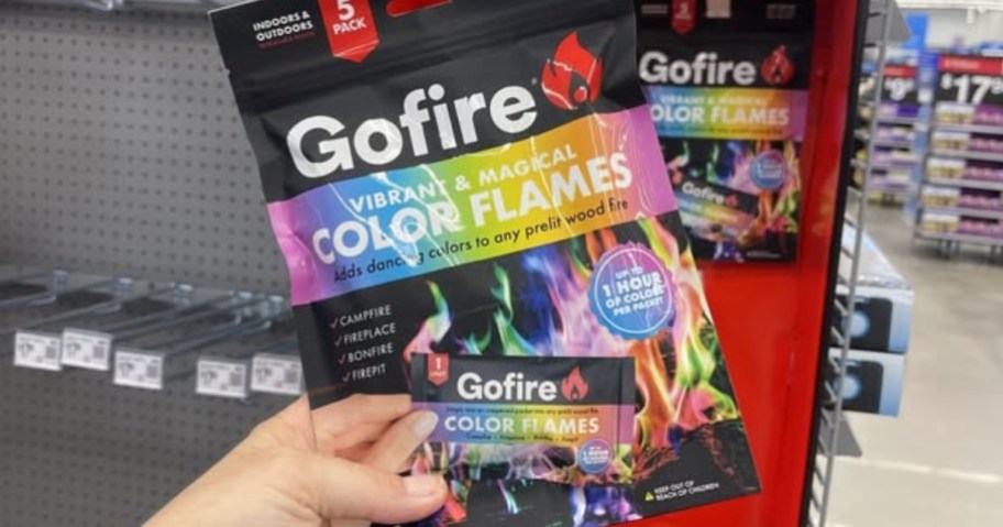hand holding a pack of GoFire Northern Lights Color Flames in a store