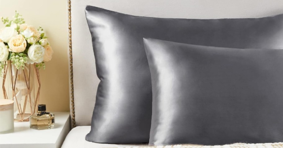 2 pillows in grey satin pillowcases on a bed