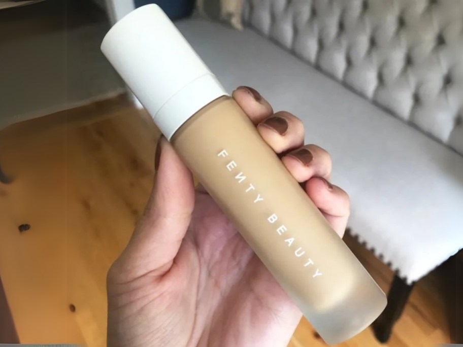 hand holding a bottle of Fenty Beauty liquid foundation