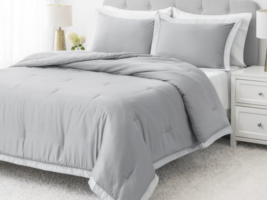 grey comforter and shams set on bed
