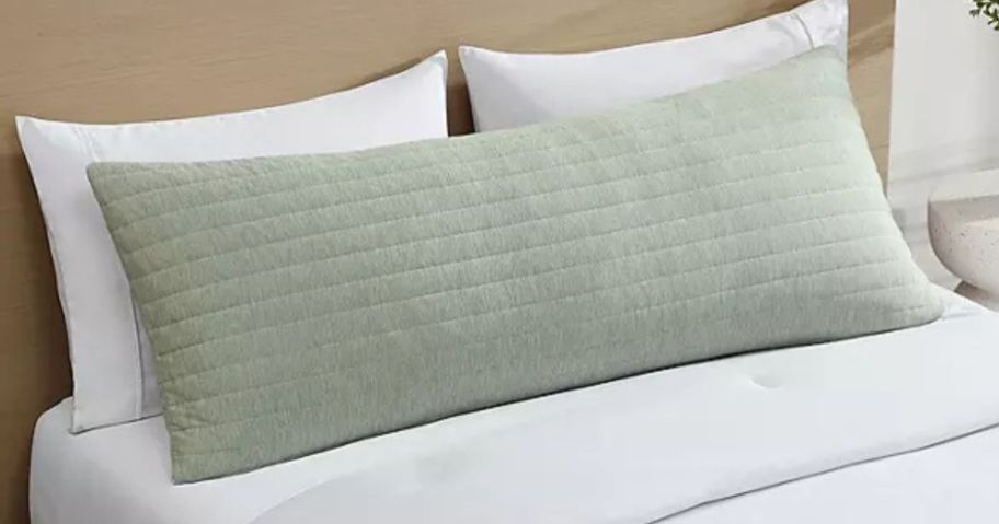 A green Hudson & Main cooling body pillow on a bed