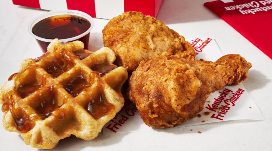 Chicken and Waffles next to syrup and a KFC bag