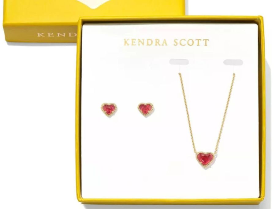 A heart necklace and matching heart earrings in a yellow box. 