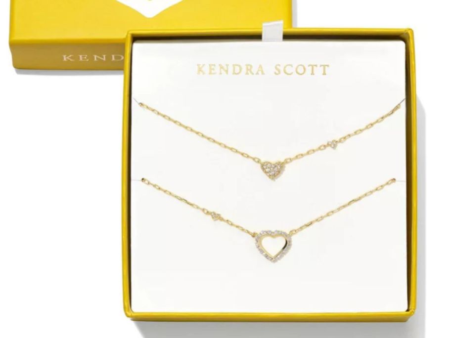 A gold box with 2 necklaces in it 