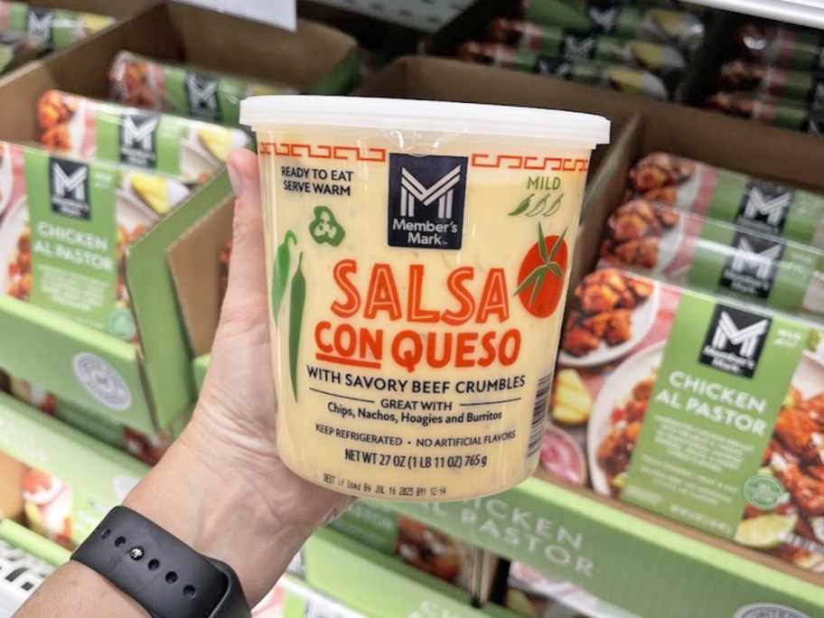 hand holding a container of Member's Mark Salsa Con Queso