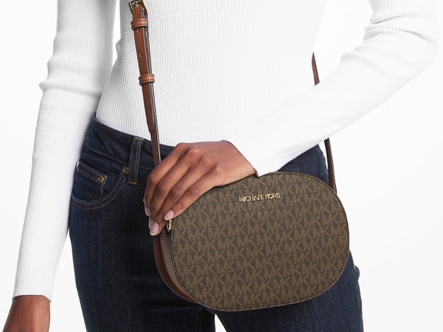 woman in a white top and jeans with brown crossbody bag