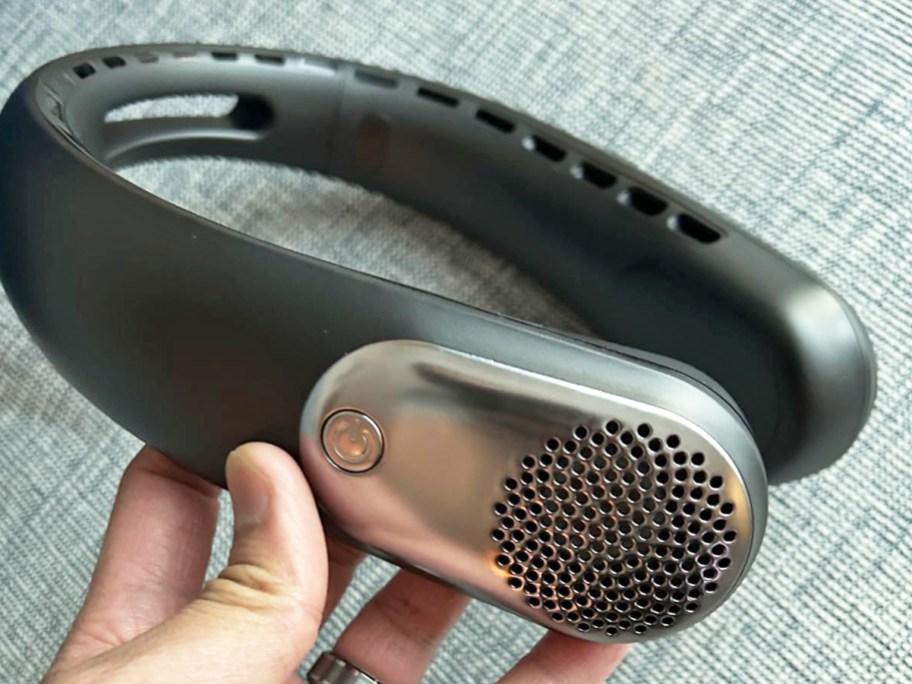 hand holding a black portable neck fan