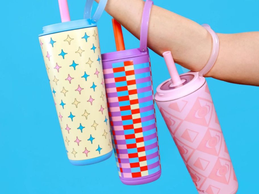 A person holding 3 Tumblers 