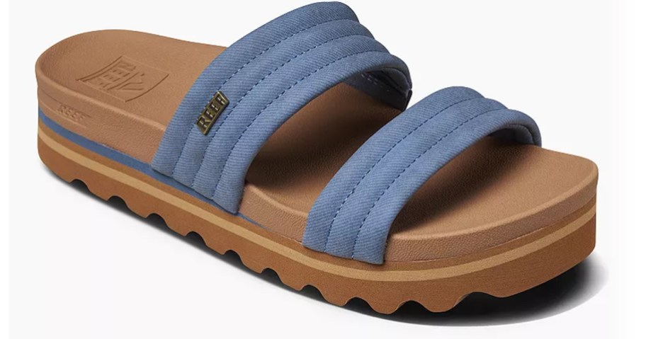 A REEF Kaia women's sandal with two wide, padded blue straps and a thick brown platform sole with a textured bottom for grip.