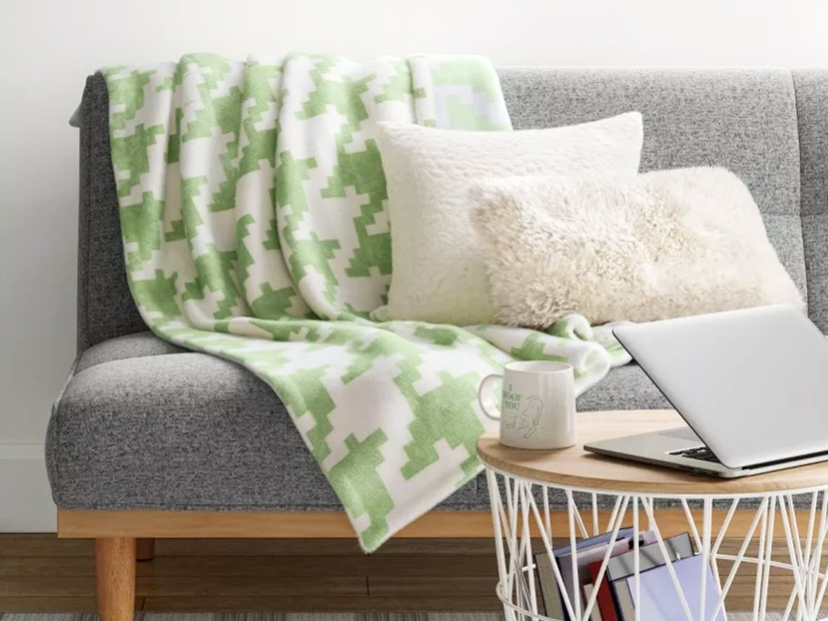 green and white houndstooth throw blanket draped over couch with white pillows