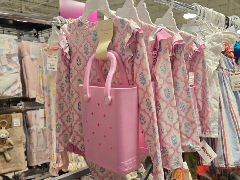 A rack of Cynthia Rowley toddler swimsuits with mini pink Bogg Bag lookalikes