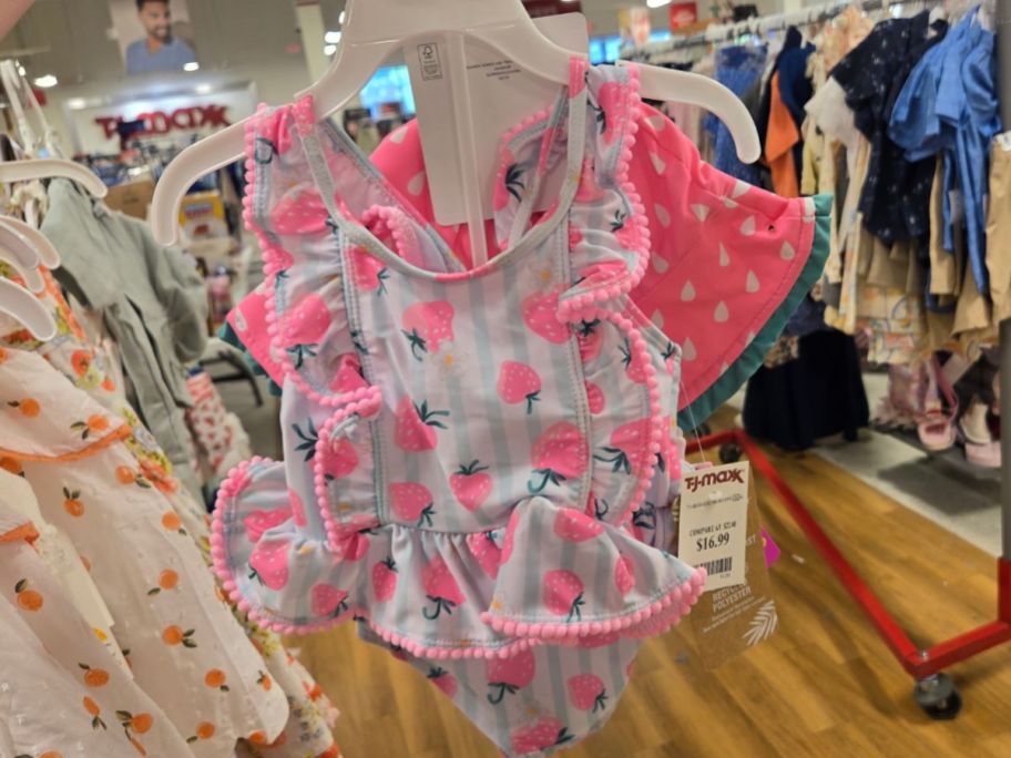 Hand holding a Tommy Bahama Toddler Girl Swimsuit & Hat Set