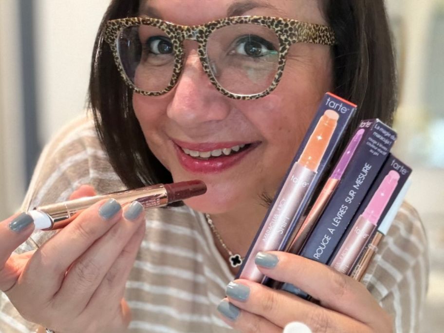 woman holding Tarte Maracuja Juicy Shift pH-Powered Plumping Gloss-Balm s while applying 0ne