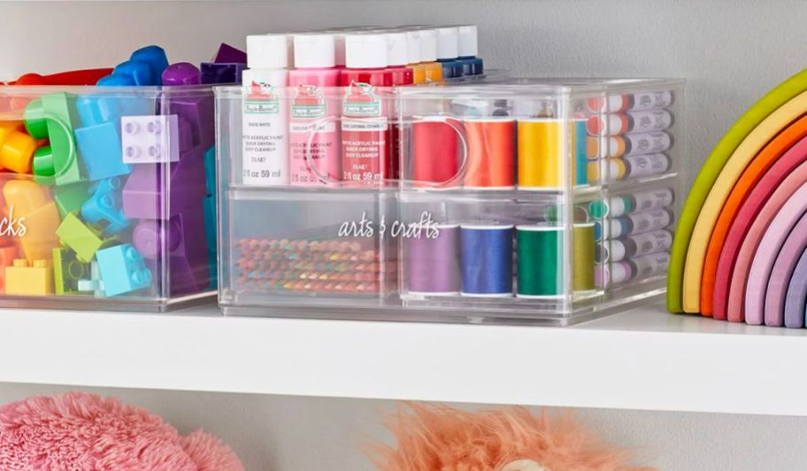 sets of clear storage bins filled with colorful craft and art supplies and legos