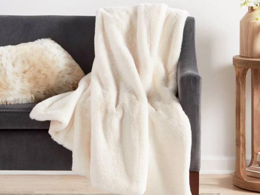 fluffy white throw blanket draped over dark grey couch