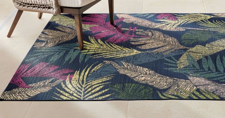 A multicolored outdoor rug with patio furniture surrounding it