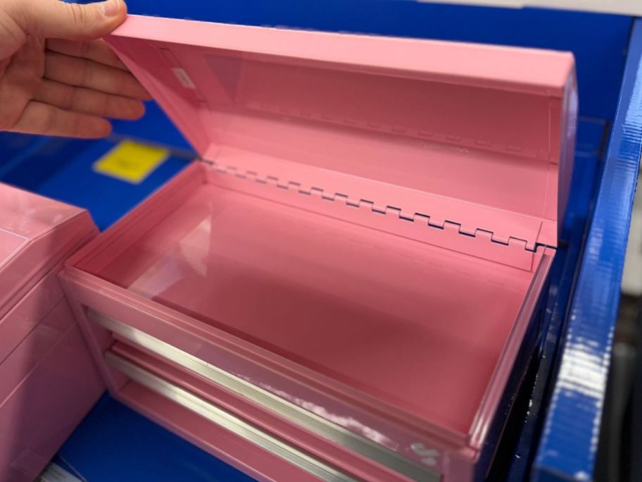 Hand opening the top of a mini tool box at Tractor Supply