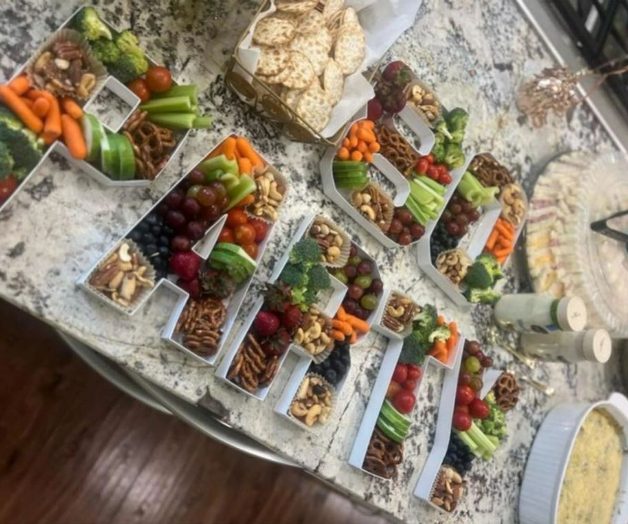 white plastic boxes filled with veggies in the shape of a letters that spell PARTY