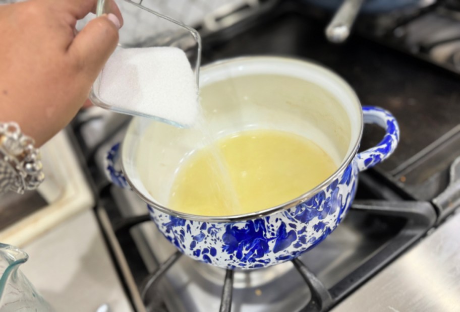adding sugar to lemon juice on the stove
