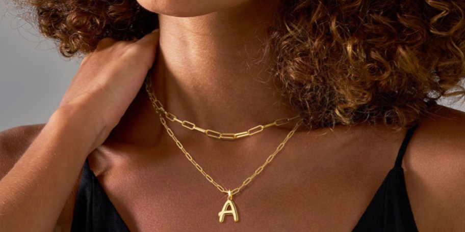 woman wearing gold a initial necklace