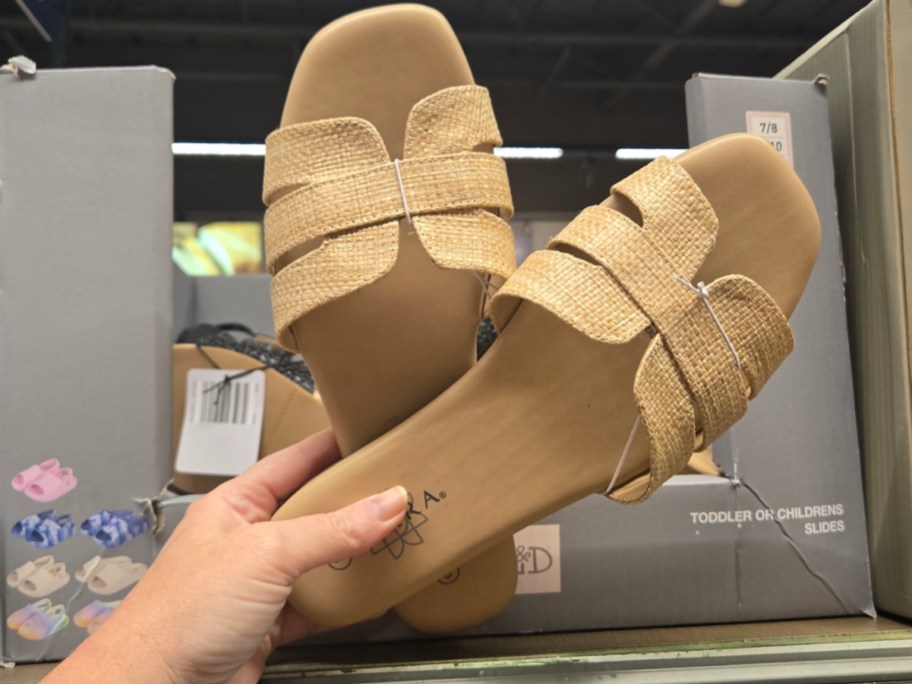 hand holding tan slide sandals 