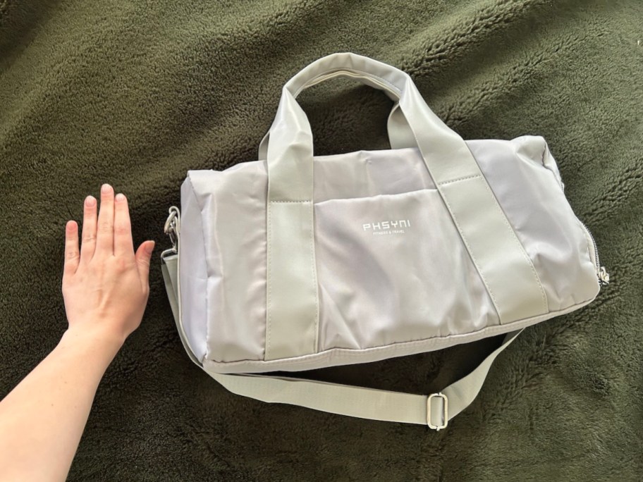 hand next to sports gym bag on floor