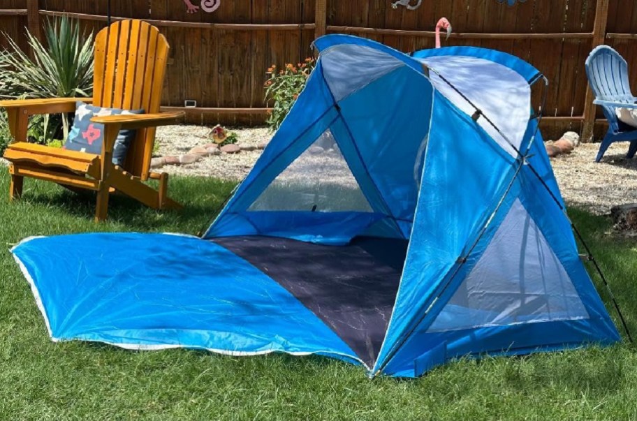 Blue amazon tent on a grassy backyard opened up next to a chair