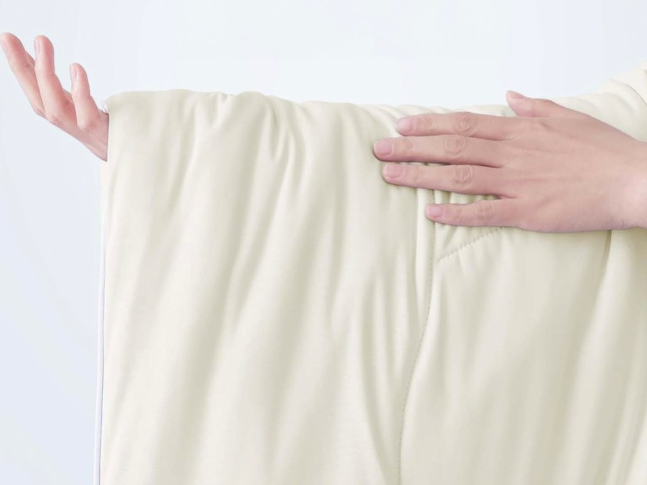 hands holding white cooling comforter 