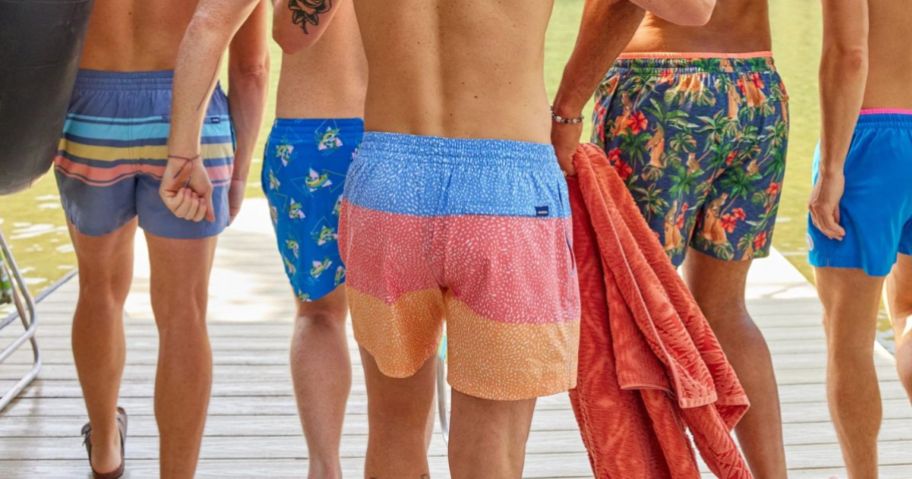 a group of men on a dock wearing chubbies swim trunks