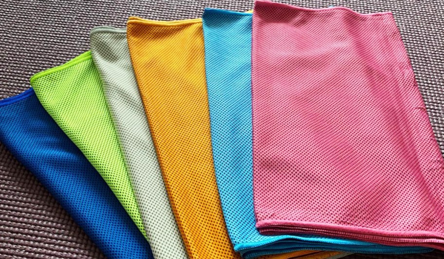 six colorful cooling towels folded on a table