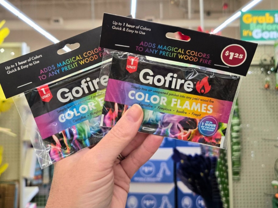 hand holding packs of GoFire fire color changing sticks in a store