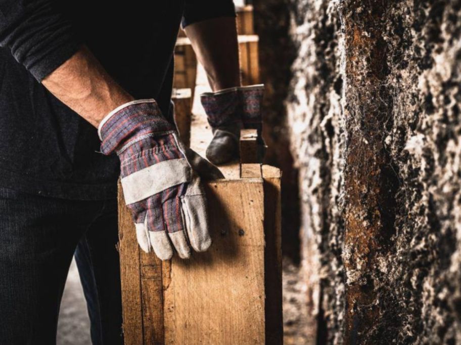 person wearing Firm Grip Leather Palm Gloves and holding wood pieces