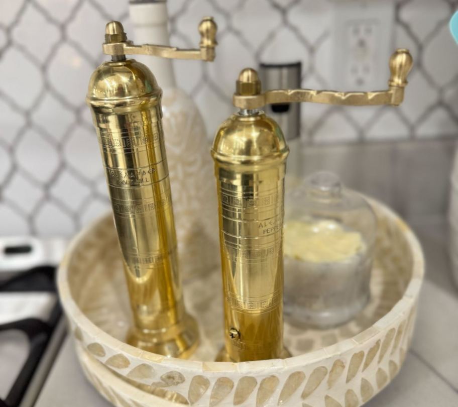gold green salt mills on tray in kitchen