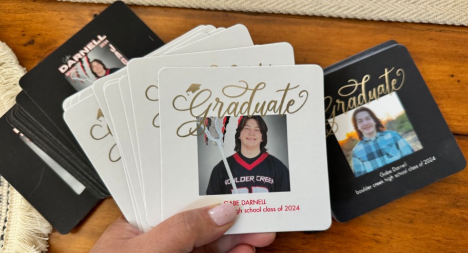 hand holding graduation coasters displayed on a table
